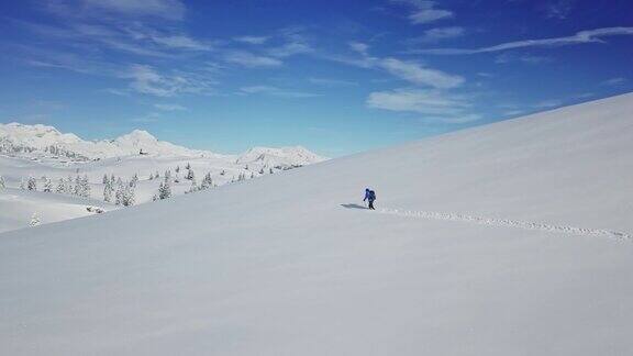 一名身份不明的徒步旅行者在卡姆尼克-萨维贾阿尔卑斯山脉的新雪中跋涉