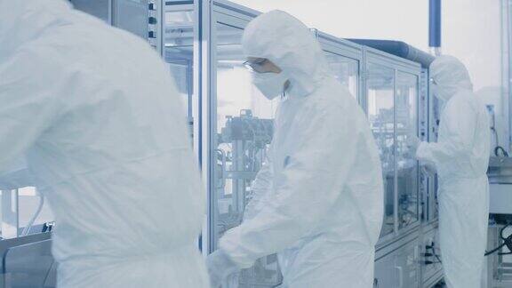 一组科学家穿着无菌防护服在科研设备前工作