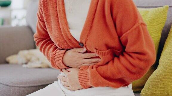 因便秘、月经或肠易激引起腹痛的女性可出现胃痛、抽筋和手痛生病了家和受苦的人在家里的休息室、沙发和客厅里憋着肚子