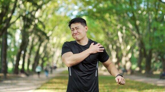 成年亚洲运动员在城市公园晨练时发生急性肩痛一名穿着运动服的悲伤男子受伤