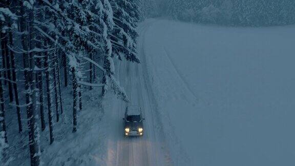 夜间所有地形车辆行驶在被雪封的森林道路上
