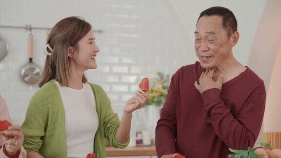 积极的情绪和烹饪的乐趣:微笑的亚洲老人准备美味的素食餐创造友谊和幸福的回忆