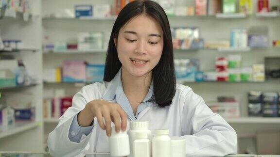 年轻的亚洲女药剂师使用视频聊天在药店介绍药物建议治疗