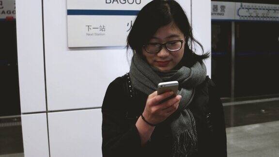 亚洲女孩在地铁站使用手机北京中国