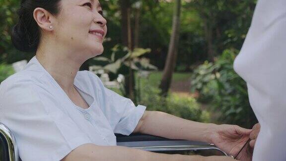 资深医生向病人解释在诊所花园中使用数码平板电脑幸福的微笑
