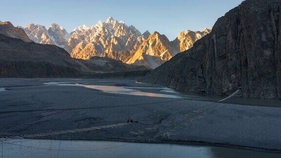 在巴基斯坦北部罕萨山谷地区的帕苏山谷的春天喀喇昆仑山脉雪山的壮丽景色的延时移动光影日落场景