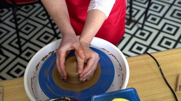 手在陶工的轮子上塑造粘土