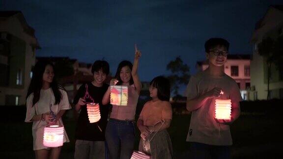 亚洲华人妈妈带着孩子和侄子拿着纸灯笼庆祝节
