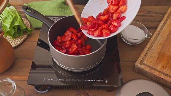 特写妇女烹饪草莓果酱蜜饯手工家庭食品在一个乡村厨房