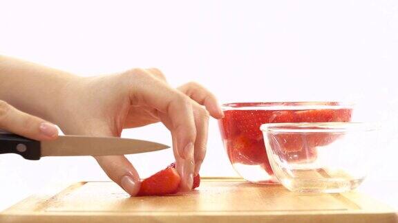新鲜的红草莓切成块采摘到碗里