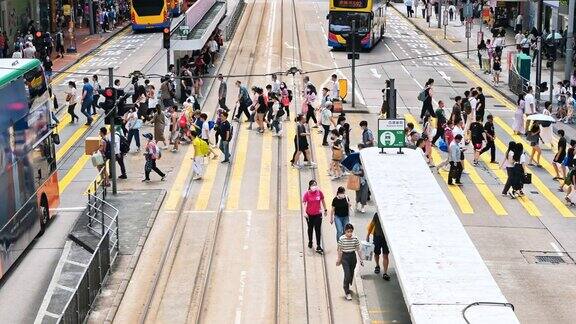在香港铜锣湾购物区中国人和亚洲游客走过斑马线电车、公共汽车、汽车等交通工具亚洲交通城市生活香港旅游理念