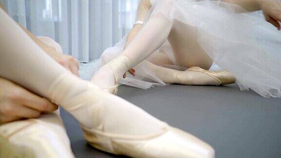 年轻的芭蕾舞女演员坐在现代工作室的地板上