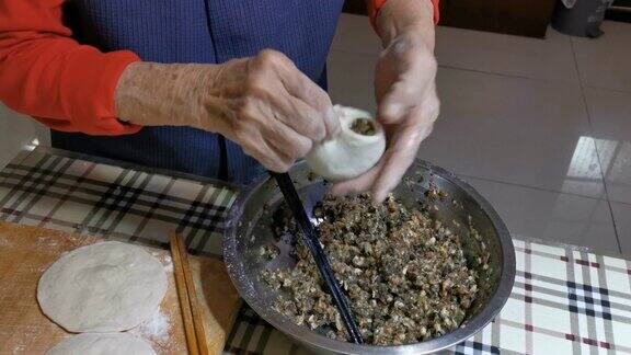 一位中国老人在家做肉包子的视频