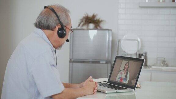亚洲资深男士在家客厅与医生视频通话病人老人咨询全科医生应用电脑医生和顾问在线和远程医疗