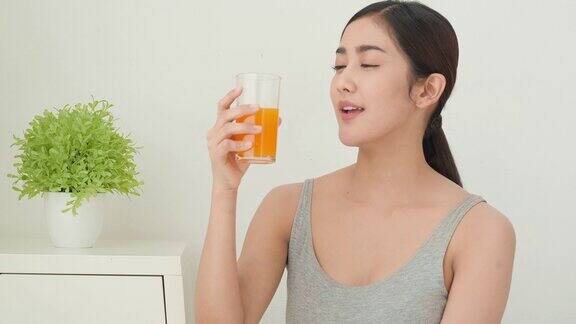 亚洲美丽的女人喝橙汁和微笑与幸福的情绪减肥饮食计划美丽健康的好处和美丽的牙齿