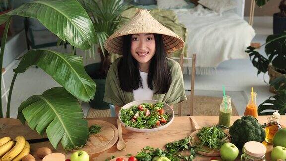美丽的年轻快乐的亚洲女人吃着健康的沙拉和新鲜的有机蔬菜