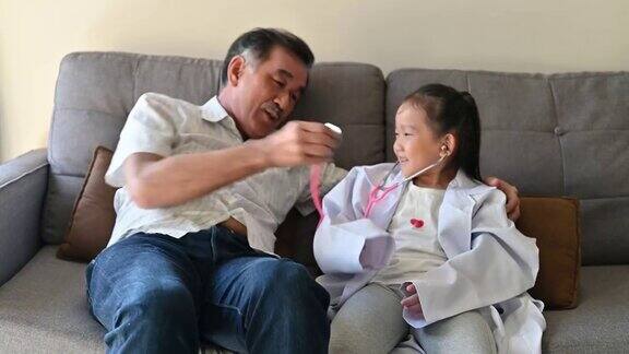 快乐有趣的亚洲学前儿童假装医生和她的祖父回家