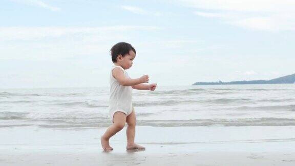 小男孩在沙滩上学习走路