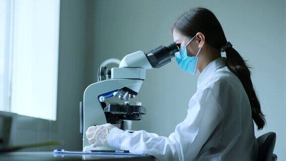 亚洲女科学家使用显微镜
