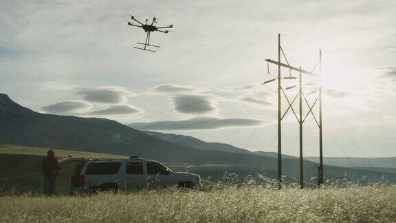 在阴天的户外一架六旋翼无人机在草地上升空飞行员操作员在一辆SUV和一些电线旁观看
