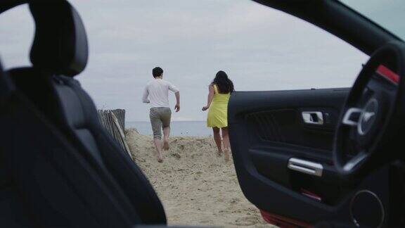 夫妇俩从车里跑向大海