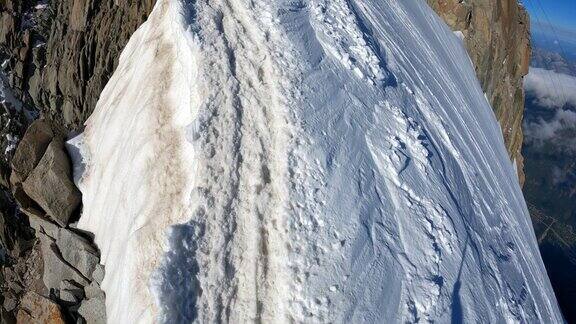 一队登山者正在攀登欧洲阿尔卑斯山的雪峰使用绳索和攀爬设备鸟瞰图