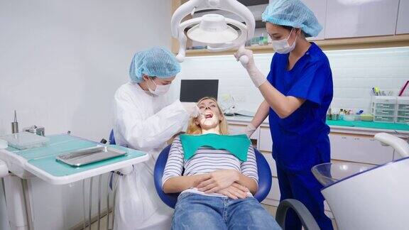 女牙医在牙科诊所为白人女孩检查牙齿美女病人躺在牙科椅上在医院预约手术期间接受医生的牙科治疗