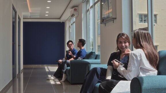 亚洲华裔护士和医生坐在沙发上聊天