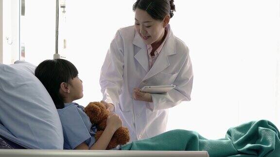 亚洲医生女检查和密切照顾病人女孩躺在医院的床上这个生病的女孩是住院的病人接受了现代化的医疗护理