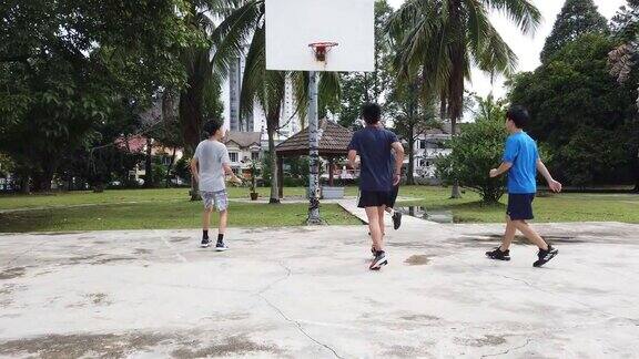 一群十几岁的亚洲华人男孩放学后在篮球场上打篮球和练习篮球
