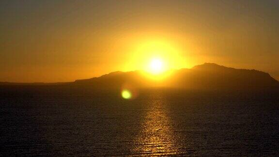 冉冉升起的太阳越过大海和沙漠山脉
