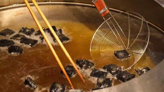 把臭豆腐放在锅里用油炸这是中国的传统小吃