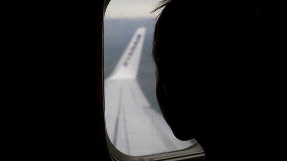 男孩坐着飞机往窗外看