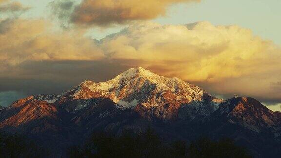 美国犹他州盐湖城白雪皑皑的瓦萨奇山在日出日落与戏剧性的云彩景观