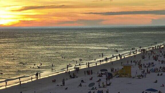 美国萨拉索塔著名的午休海滩柔软的白色沙滩许多人享受度假时光在温暖的海湾水中沐浴在佛罗里达州的夕阳下晒黑