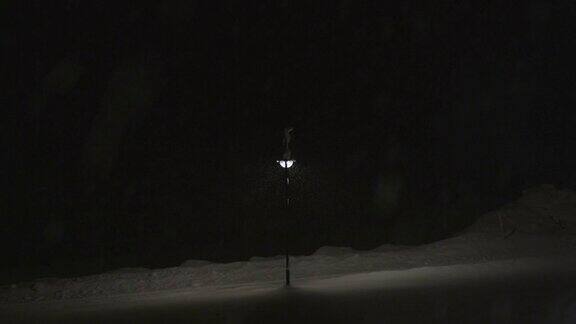 灯柱照亮了一个下雪的夜晚在韦尔比尔