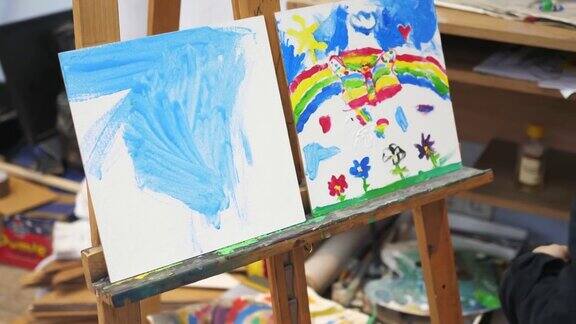 小女孩在画架画室画蓝色背景的天空