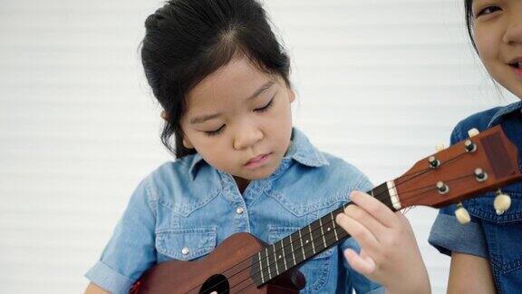 年轻的中国女孩在音乐课上练习尤克里里琴有着很棒的教育理念