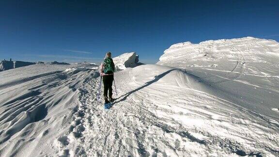女人走在雪鞋在阿尔卑斯山的新雪GrosserSpeikkogelStyria奥地利