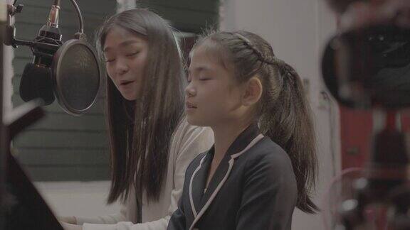 亚洲女孩与老师在线学习钢琴