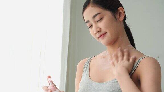 亚洲美女涂抹香水乳液霜在身体上年轻女子因爱皮肤而保重自己美丽、健康和化妆品