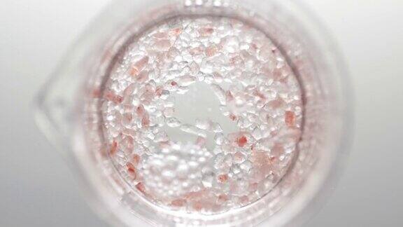 棕盐的晶体落在液体中形成气泡