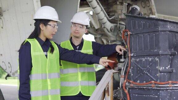 飞机亚洲工程师团队维修检查和工作飞机引擎在机库