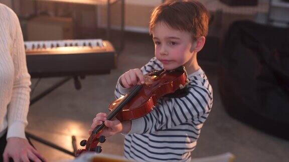 一个年轻女子在教一个小男孩拉小提琴