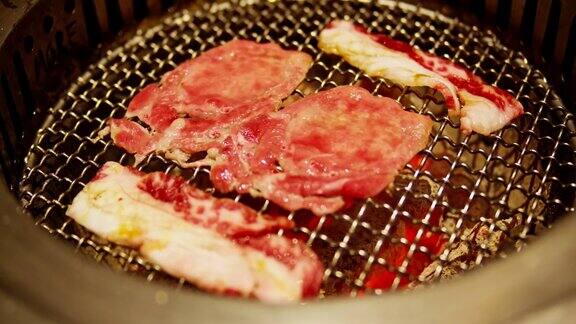 烧烤在餐厅的木炭烤架上烤新鲜多汁的牛肉片