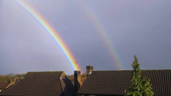 在阴天美丽的双彩虹越过屋顶和烟囱