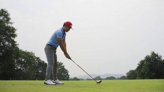 一名职业亚洲男性高尔夫球手在高尔夫球场上表演发球的镜头