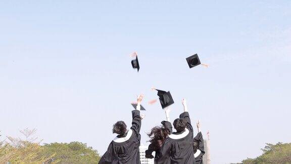 快乐的学生跑着把毕业帽扔向空中