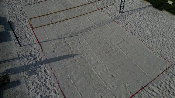 白色的沙滩排球场白色柔软的沙丘用网围起来运动场的线条是由蓝色纺织塑料带制成的
