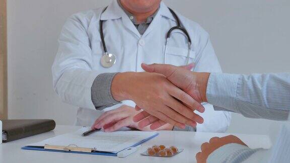 医生和男性病人咨询和诊断检查坐下来和病人谈论药物在医院靠窗的那张桌子上